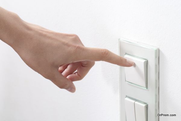 Woman hand turning operating a wall switch