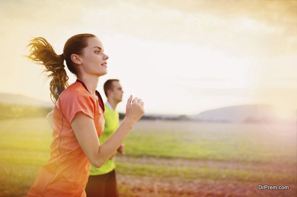 Cross-country trail running people at sunset. Runner couple exercising outside as part of healthy lifestyle.