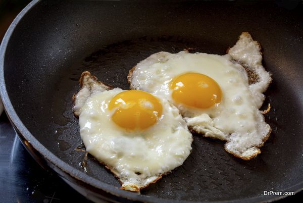 two fried eggs in a black pan