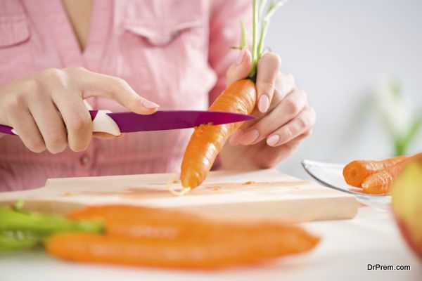 close up of female hands cutting carrot