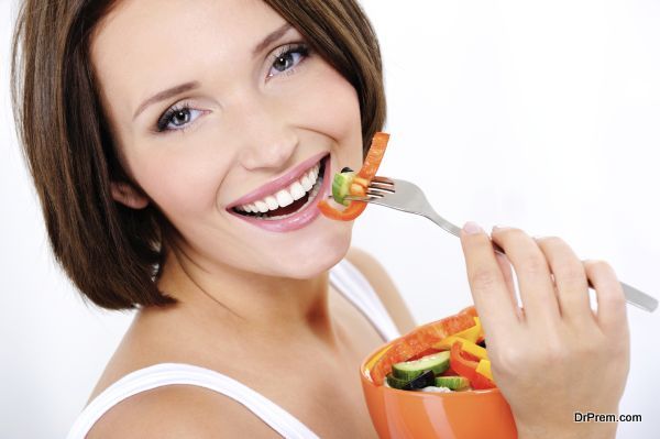 Portrait of a happy attractive young woman eats vegetable salad