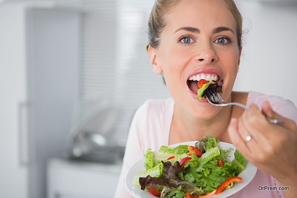 Casual blonde posing while eating salad