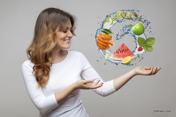 smiling woman with fruits and water splash on grey background