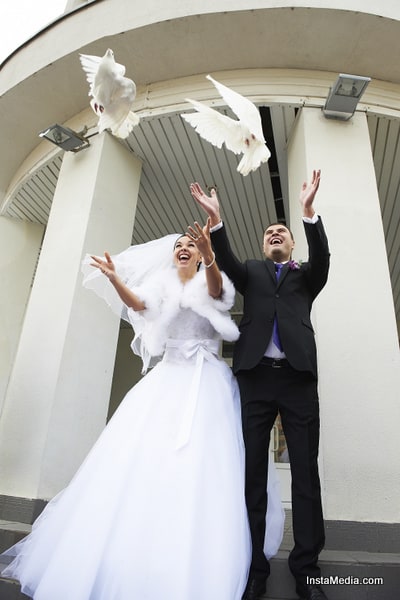 Joyful Bride and groom release pigeons