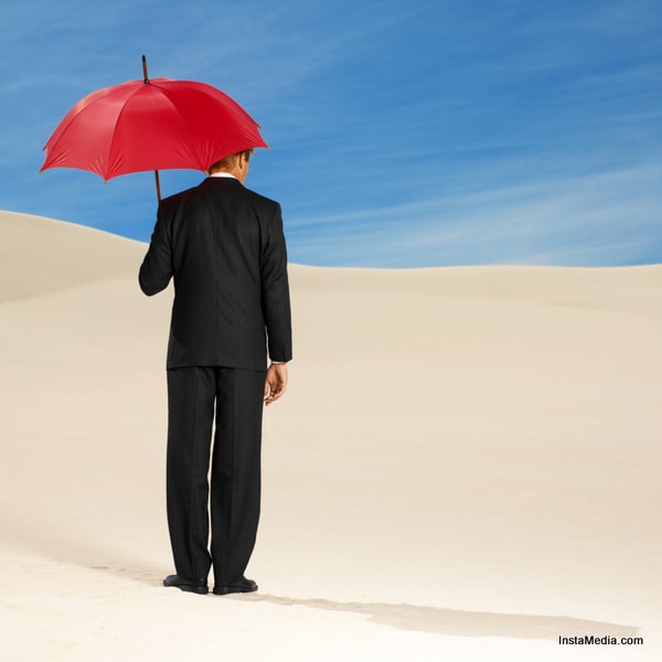 rear view of a man standing holding an umbrella