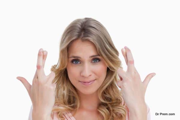 Smiling young woman crossing her fingers