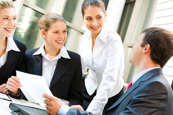 Image of three women looking at business man in a office