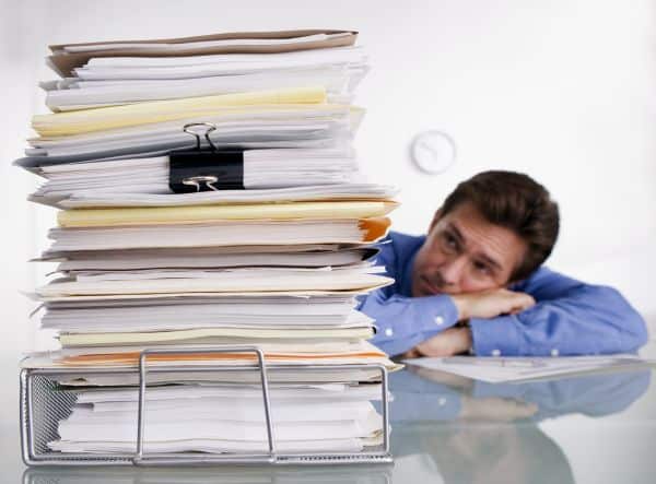 Businessman Overwhelmed with Paperwork --- Image by © Royalty-Free/Corbis
