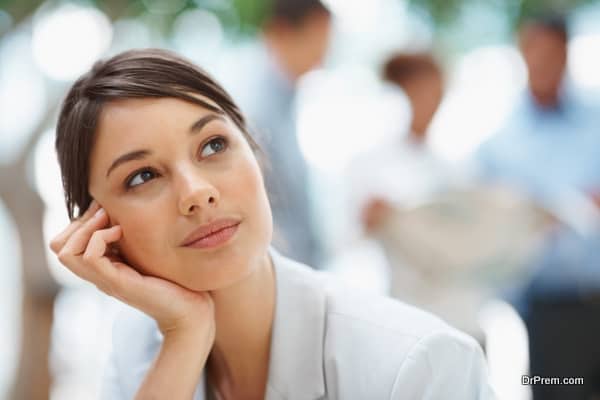 Cute young thoughtful business woman looking away