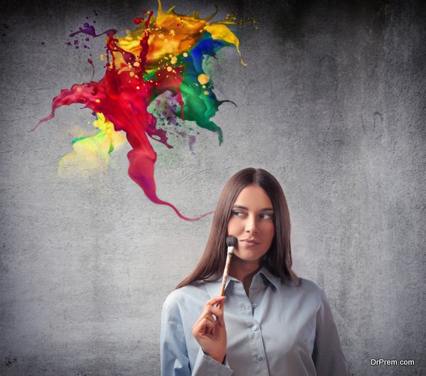 Beautiful woman holding a paintbrush with colors coming out from it