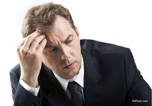 stressed businessman touching his head while thinking