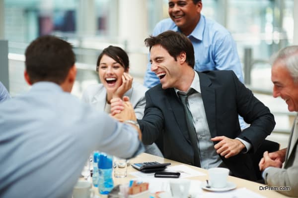 Happy man joining hands in unity with colleague at meeting