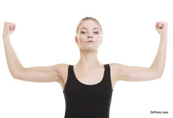 Fitness woman showing energy flexing biceps