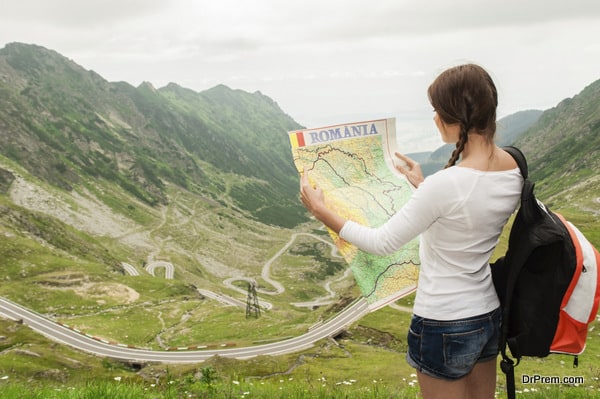 Girl tourist in mountain read the map