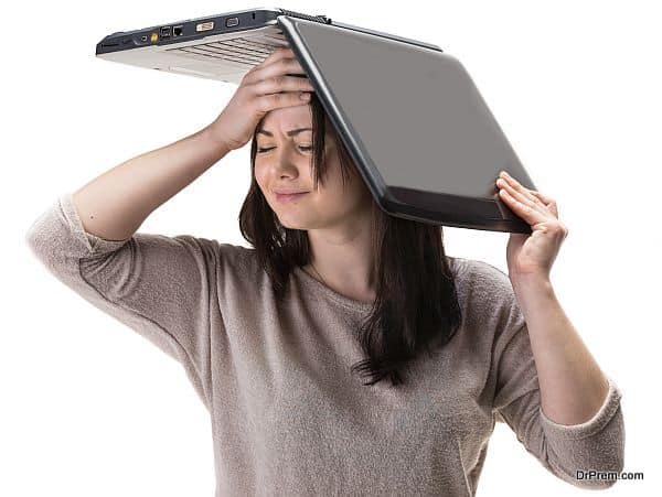 Stressed young woman with a laptop on her head