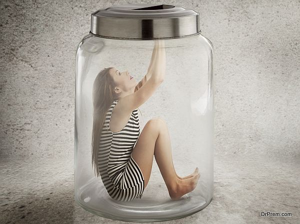 Young lonely woman sitting in glass jar