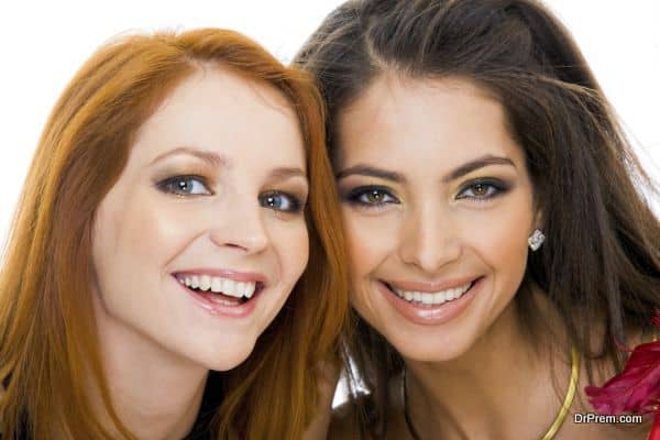 Faces of two young ladies looking at camera with happy smiles