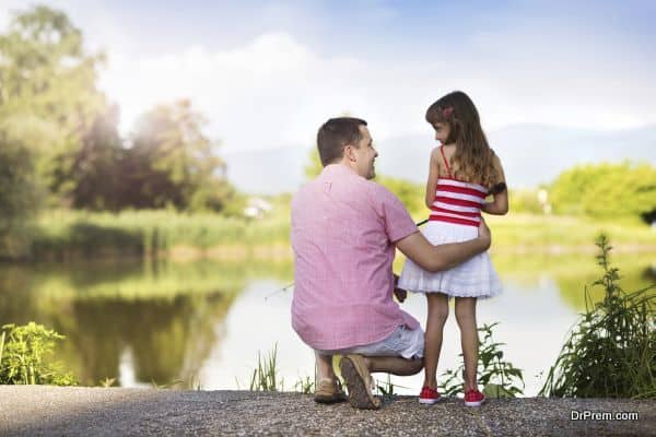 Happy young father fishing on the lake with his little daughter