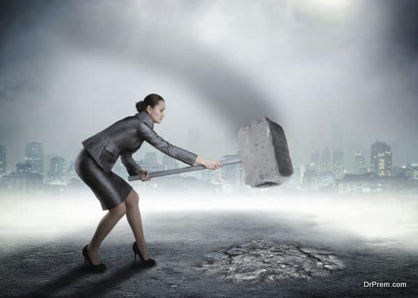 Businesswoman with sledgehammer banging the ground