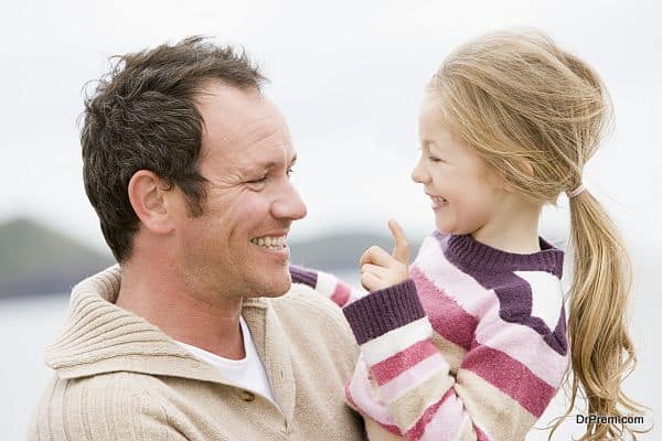 Father and daughter at beach smiling