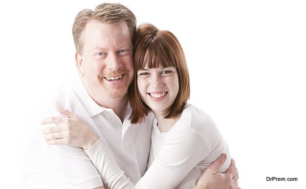 A head and shoulders image of a caucasian real family with a father hugging his teenage daughter. Marty and Anna Cline