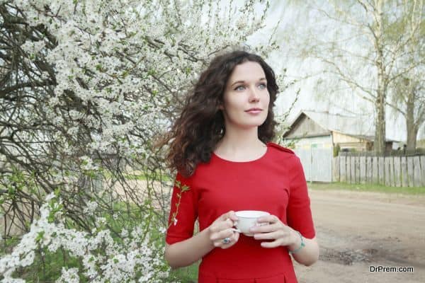 Daydreaming attractive brunette girl at spring fruit tree in bloom