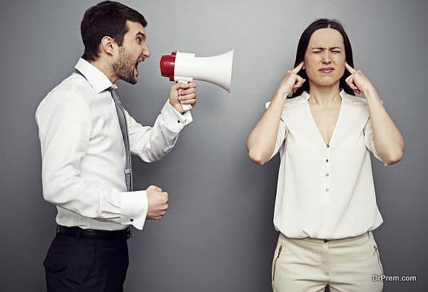 man screaming in megaphone at the woman