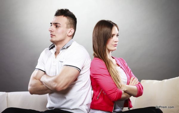 Bad relationship concept. Man and woman in disagreement. Young couple after quarrel sitting on sofa back to back