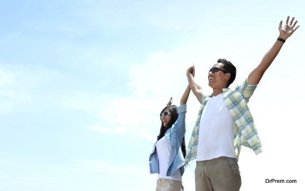 Portrait of asian young couple standing and raised their hands to the sky