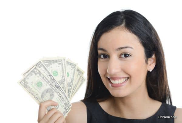 isolated portrait of beautiful and successful young business woman holding us dollar bills