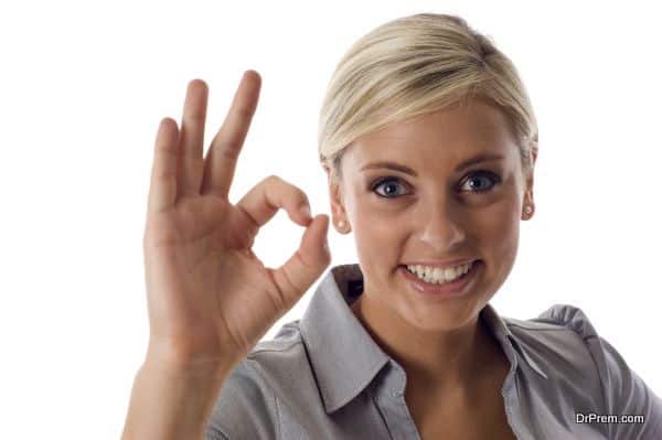 Smiling business woman showing okay sign isolated over a white background