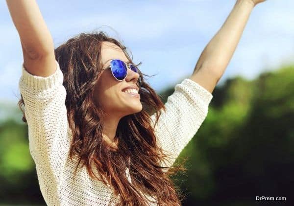 Attractive happy woman in sunglasses enjoying freedom outdoors w