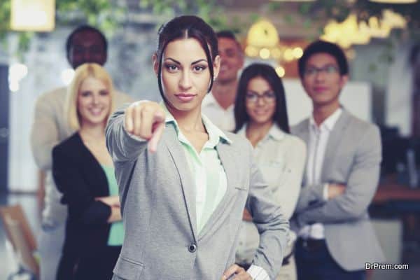 Businesswoman pointing at camera in front of colleagues