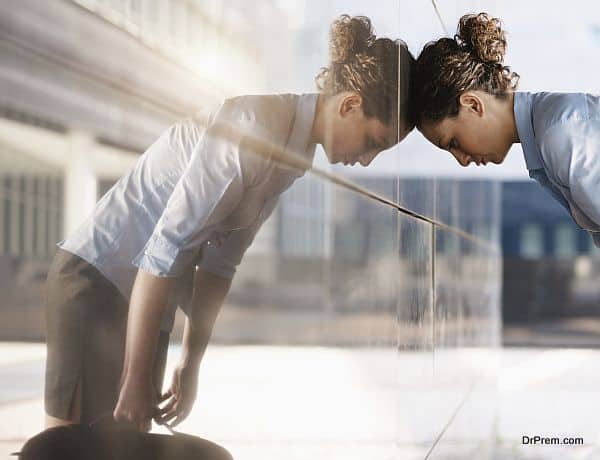 mid adult italian business woman banging her head against a wall outside office building. Square shape, copy space