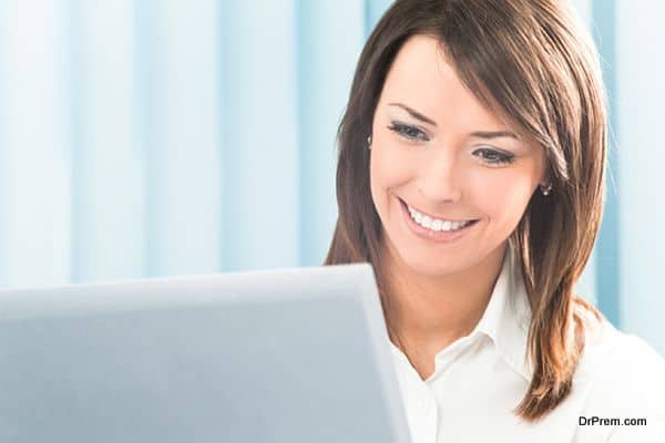 Happy smiling businesswoman with computer at office