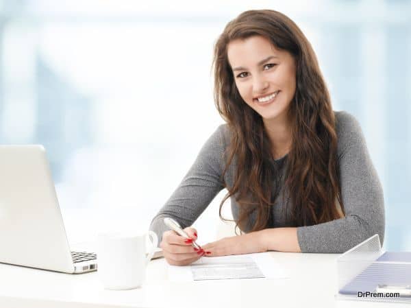 Portrait of young businesswoman fill the form while sitting at office.