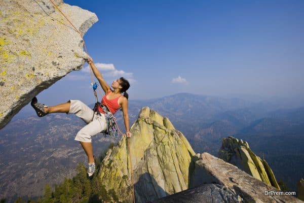 Female rock climber rappelling.