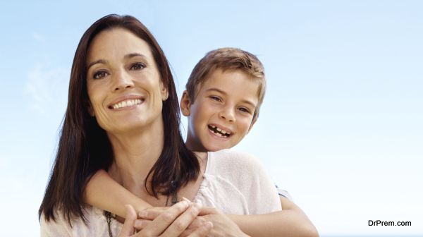 Cute little boy hugging his mom and smiling - copyspace