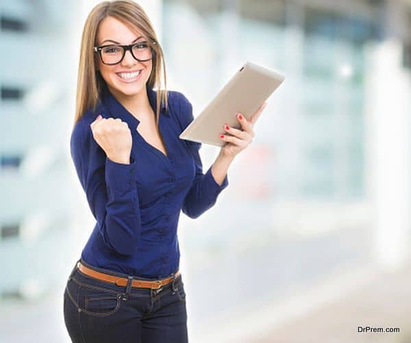 Excited happy young woman wearing glasses with tablet computer