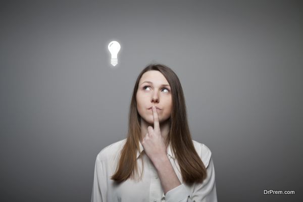 Young woman having an idea with light bulb over her head.