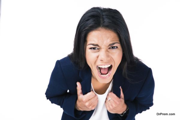 Angry businesswoman screaming over white background and looking at camera