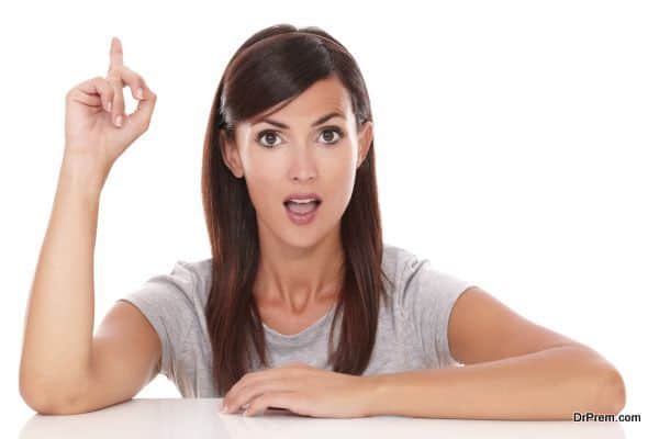 Portrait of surprised woman pointing up her finger while looking at you on isolated white background - copyspace