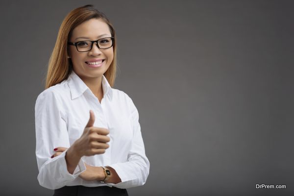 Portrait of smiling Asian business woman showing thumbs-up