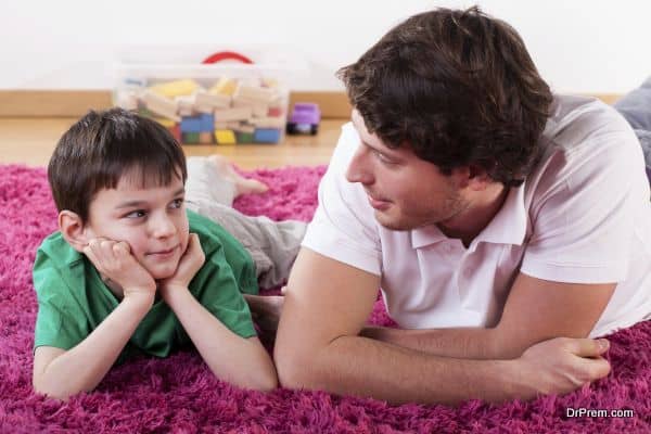 A young handsome dad lying on the floor with his son