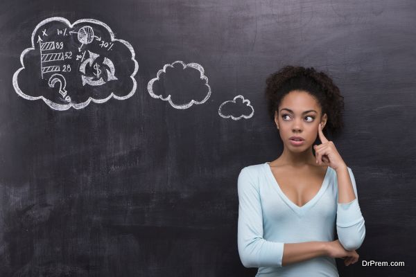 Photo of young thoughtful afro-american woman on chalkboard background. Woman looking at problem she trying to solve