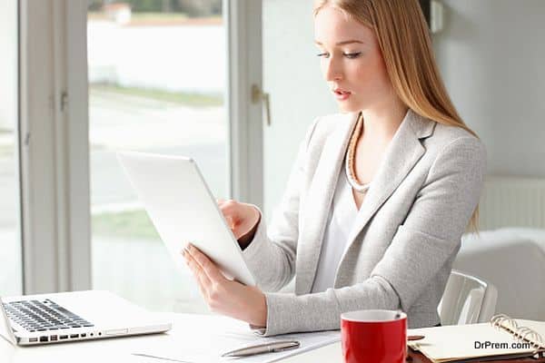 Attractive business woman is typing on her tablet