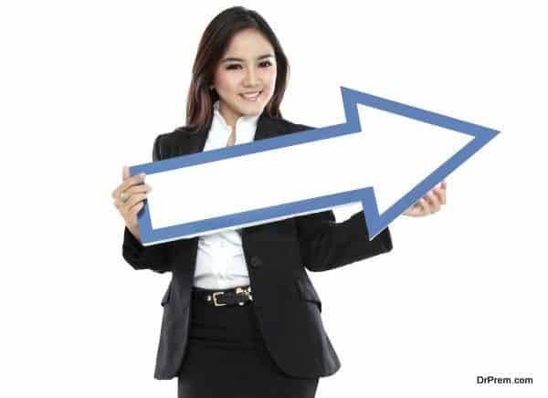 smiling businesswoman with direction arrow sign on white background