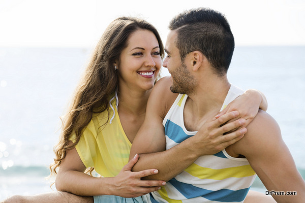 Happy twosome having romantic date on sandy beach