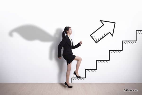 Superhero Business woman stepping up on stairs to gain her success with white wall background, asian