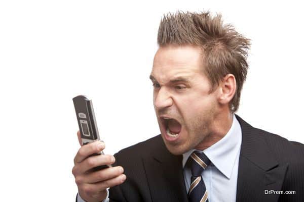 Businessman has stress and sreams into mobile phone